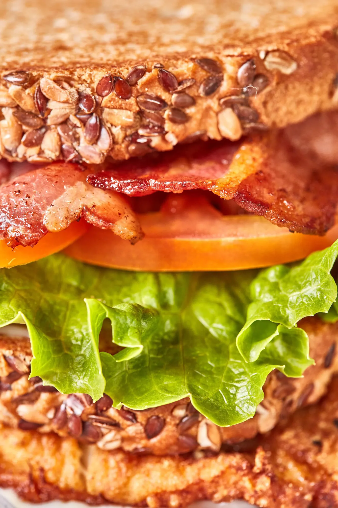 Closeup of a BLT sandwich with crispy bacon and seeded bread