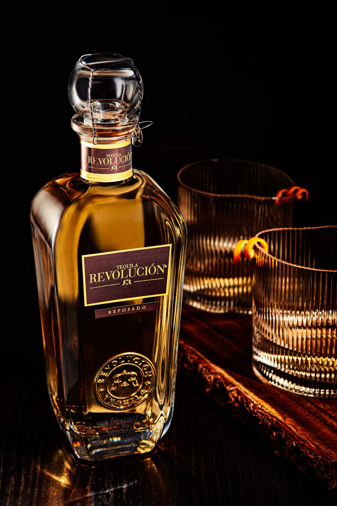 Whisky bottle with glasses on dark elegant backdrop.