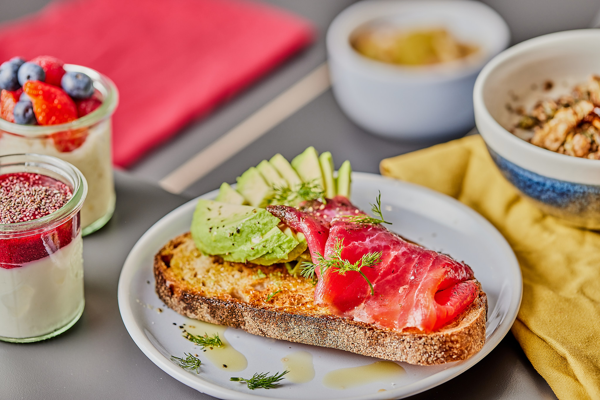 Avocado salmon toast with yogurt and berries breakfast.