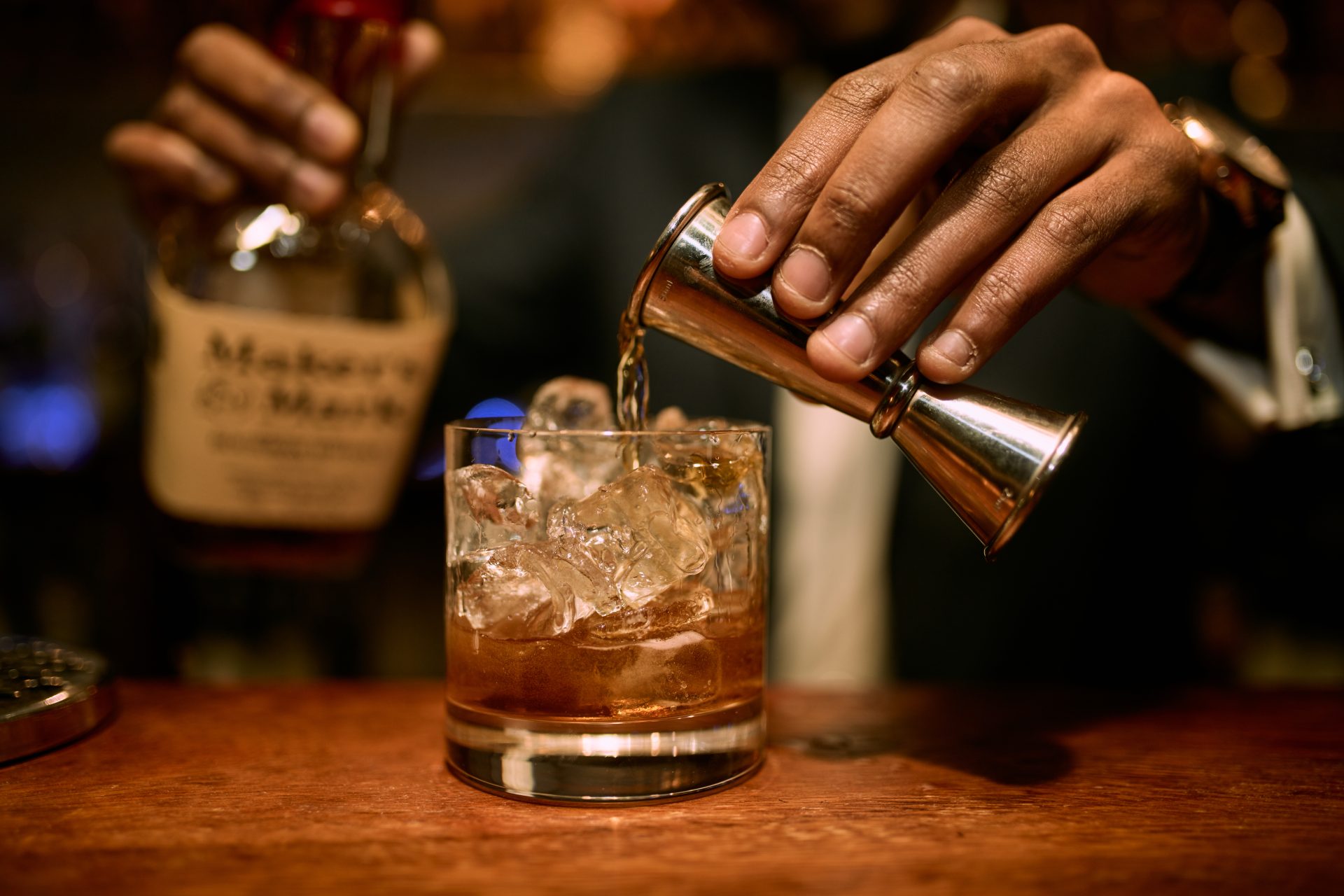 Crafting a Whiskey Cocktail with Makers Mark in a Cozy Bar.